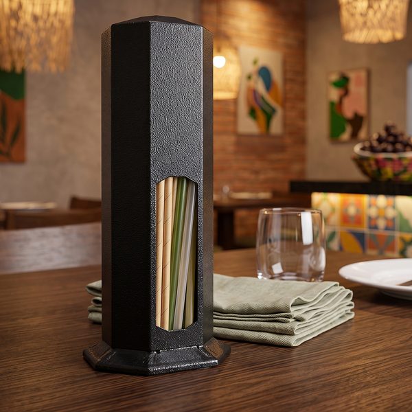 Porta canudo sextavado em epóxi preto sobre mesa de restaurante